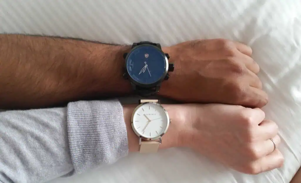 Blue and beige stylish wristwatches on couple's wrists, showcasing fashion accessories for men and women.